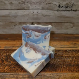 Bloke handmade Hand & Body Soap with earthy brown and calming blue swirls on a creamy base, placed on a rustic wooden surface, created by Catherine Noel.