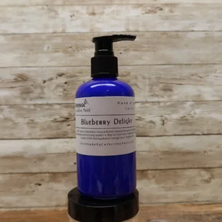 Blueberry Delight Hand & Body Lotion in a blue bottle with vibrant labeling, set against a rustic wooden background.