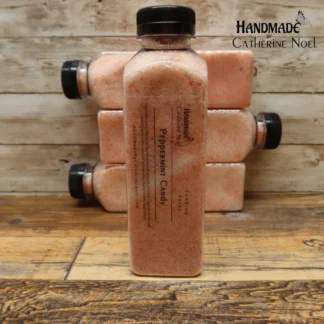 Exotic Retreat Soaking Salts Alt Text: Exotic Retreat soaking salts in a clear plastic bottle with warm yellow and cream tones, labeled "Handmade by Catherine Noel," displayed on a rustic wooden background. Caption: Exotic Retreat Soaking Salts – Transform your bath into a luxurious tropical getaway with handcrafted soaking salts. Description: Exotic Retreat Soaking Salts by Catherine Noel feature warm yellow and cream tones, perfect for creating a luxurious tropical bath experience. Infused with a rich, exotic scent, these salts nourish and soothe your skin, making every soak feel like a retreat. Frosted Whimsy Soaking Salts Alt Text: Frosted Whimsy soaking salts in a clear plastic bottle with delicate pink tones, labeled "Handmade by Catherine Noel," displayed on a rustic wooden surface. Caption: Frosted Whimsy Soaking Salts – Add a touch of magic to your bath with these pink, whimsical salts. Description: Frosted Whimsy Soaking Salts by Catherine Noel are delicately crafted with pink tones and a whimsical scent. These salts create a calming, luxurious bath experience, leaving your skin feeling refreshed and rejuvenated. Love Bomb Soaking Salts Alt Text: Love Bomb soaking salts in a clear plastic bottle with romantic lavender and pink tones, labeled "Handmade by Catherine Noel," displayed on a rustic wooden surface. Caption: Love Bomb Soaking Salts – Infuse your bath with love and relaxation with these romantic salts. Description: Love Bomb Soaking Salts by Catherine Noel feature romantic lavender and pink hues. Designed for a deeply relaxing bath experience, these salts combine soothing properties with a captivating floral scent. Peach Bliss Soaking Salts Alt Text: Peach Bliss soaking salts in a clear plastic bottle with soft peach tones, labeled "Handmade by Catherine Noel," displayed on a rustic wooden surface. Caption: Peach Bliss Soaking Salts – Indulge in the sweet, fruity aroma of peaches with these luxurious salts. Description: Peach Bliss Soaking Salts by Catherine Noel bring a touch of sweetness to your bath with their soft peach tones and fruity aroma. These handcrafted salts nourish and refresh your skin while providing a relaxing soak. Peppermint Candy Soaking Salts Alt Text: Peppermint Candy soaking salts in a clear plastic bottle with vibrant red and white tones, labeled "Handmade by Catherine Noel," displayed on a rustic wooden surface.