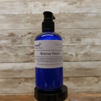 Winter Frost Hand & Body Lotion in a blue frosty-themed bottle, set against a rustic wooden backdrop.